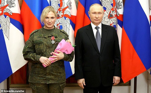 Putin is seen awarding the mysterious blonde woman a medal before his New Year's TV address.