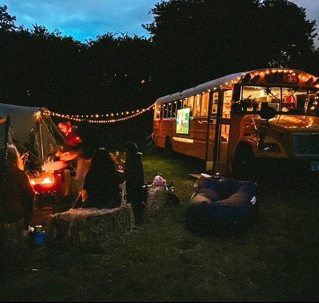 The bus looks cute and cozy with fairy lights during an evening garden party outside the house.