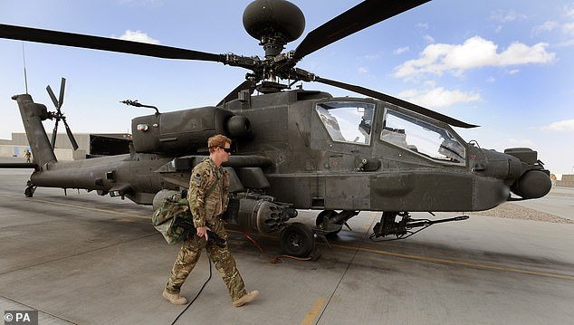 Prince Harry pictured next to an Apache helicopter on October 31, 2012. He revealed in his memoir that all the deaths were recorded on video, which was later played back and analysed.