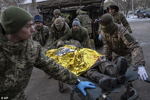 Ukrainian military medics carry an injured Ukrainian serviceman evacuated from the battlefield into a hospital in Donetsk region yesterday