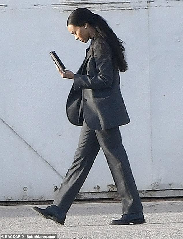 Taking her role seriously: Zoe Saldana, 44, dressed in business attire and pulled her long hair back into a ponytail as she prepared to film scenes from the spy movie