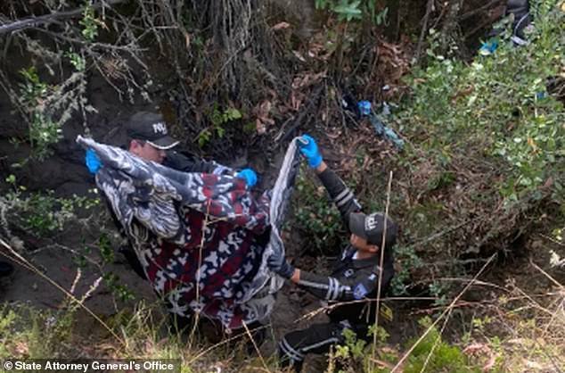 Ecuadorian police remove a blanket from the ditch where the body of María Bernal was buried by her husband, former police lieutenant Germán Cáceres