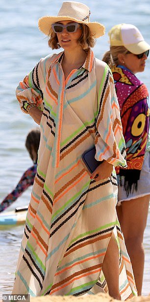 Zoë, 42, turned heads in a neon-striped dress by Devotion, valued at $789, and a wicker sun hat.