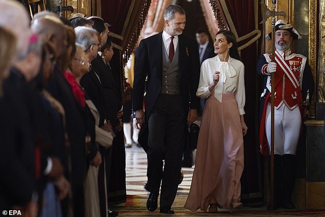 The royal couple shared a tender moment as they entered the room where diplomats had lined up to greet them.