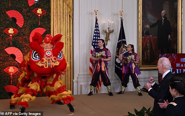 President Joe Biden cheers on a dragon dance performed by the Choy Wun Lion Dance Company in the East Room of the White House on Thursday night.