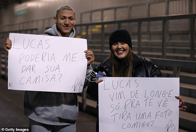 Moura's Tottenham teammate Richarlison came to support and held up a sign asking for the striker's shirt.