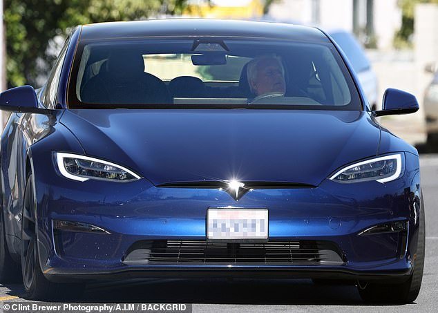 He stopped to speak to photographers outside the garage and reportedly commented on his show being canceled before driving around in his blue Tesla.
