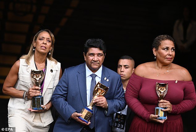 EKely (right) and Flavia Nascimento (left) and the president of the Brazilian Football Federation (CBF) Enaldo Rodrigues (C) show the Jules Rimet trophies won by Pelé during the last Brazilian Super Cup soccer match between Palmeiras and Flamengo in Brasilia, Brazil, January 28, 2023. EPA/André Borges