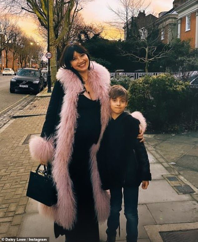Stunning: In a second image, the model, 34, bundled up in a chic pink fur-trimmed long jacket as she posed with her friend's son.