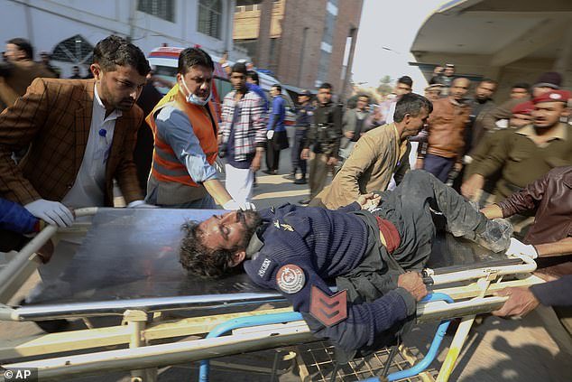 An injured man is stretchered away from the bomb site. The death toll from a suicide bombing at a mosque in north-western Pakistan has risen more than 90, officials said on Tuesday