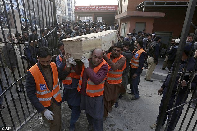 Volunteers carry the coffin of a man, killed in the suicide bombing inside a mosque, at a hospital, in Peshawar, Pakistan, on Monday