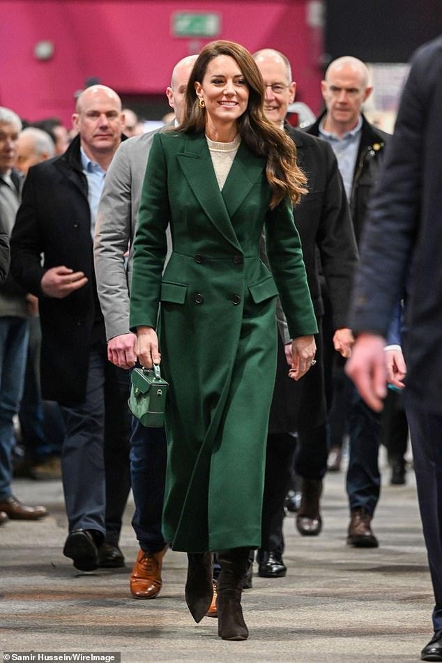 The Princess of Wales pictured touring the Leeds market this morning.  She wore a green longline coat, dark brown suede boots, and a cream-colored dress.