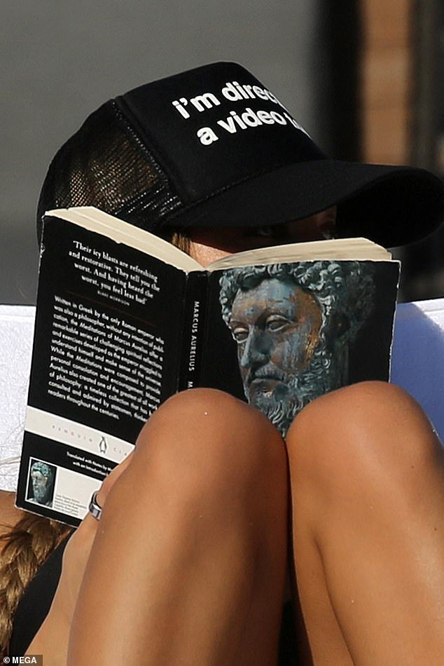 Passing the time: While sunbathing he read his book