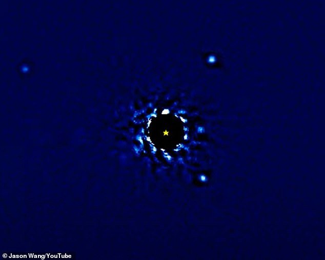 It was put together with the help of 12 years-worth of observations and shows the exoplanets as dots of light circling a black disk