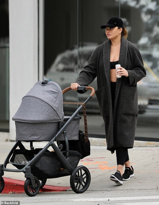 hot mom!  As she braved the rain on a walk in Los Angeles, the former Sports Illustrated model looked as slim as ever as she pushed a gray stroller down the sidewalk.