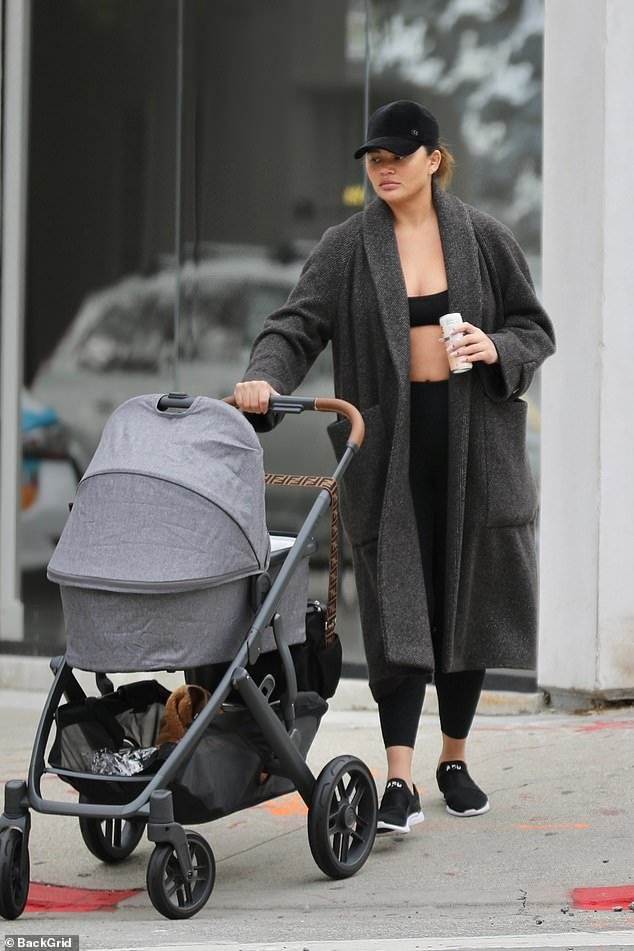 Looking good!  Chrissy Teigen showed off her svelte postpartum body in a black sports bra under a long fleece jacket as she stepped out with all three of her children for the first time.
