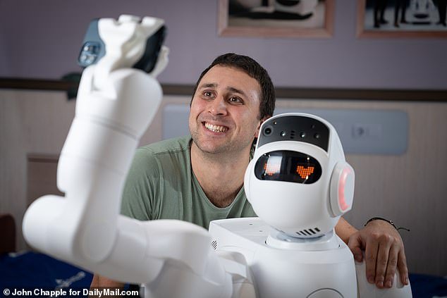 Gently opening the door to the hospital room, Aeo peeps inside to check on a sleeping patient. Pictured: The Mail on Sunday's Senior Health Reporter with Aeolus Robotics, Aeo