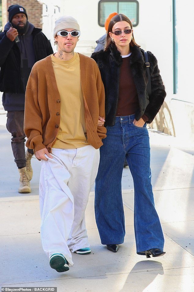 Happy couple: Hailey Bieber showed off her sensational sense of style in a maroon T-shirt under a fuzzy black jacket as she walked arm in arm with her husband, Justin, on Tuesday