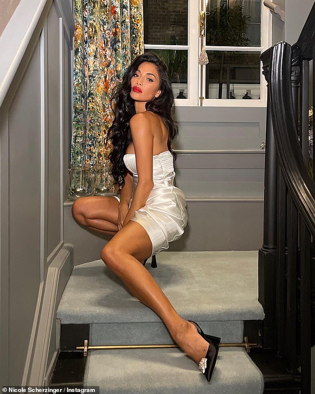 Sensational: Nicole Scherzinger got busty in a stunning off-white satin gown and hiked it up to show off her legs on Instagram on Wednesday
