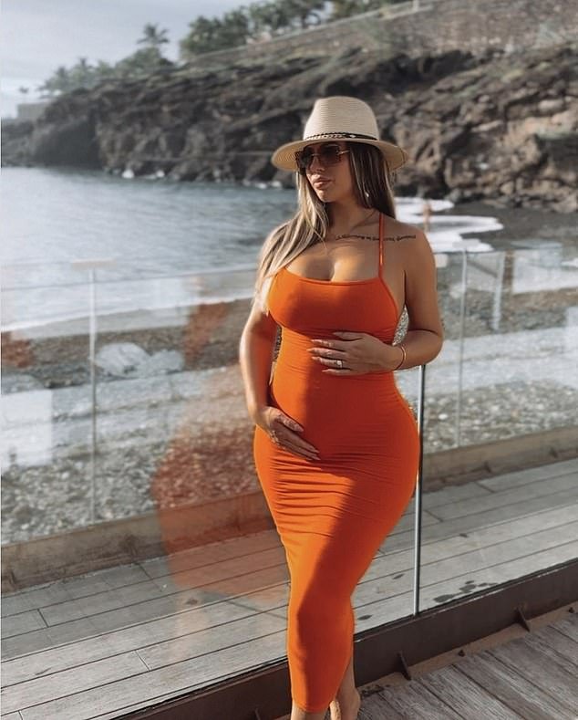 Gorgeous: Pregnant Holly Hagan cradled her growing baby bump as she posed in a figure-hugging orange dress on Monday