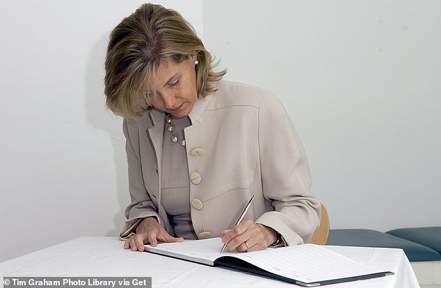 The Duchess of Edinburgh tackles a visitor's book during a visit to Southwark in June 2004