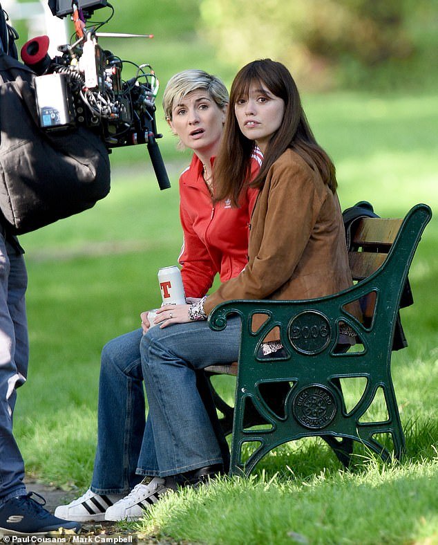 Toxic Town: Jodie looked unrecognizable in a red vintage Adidas jacket as she was pictured holding a can of beer in the park (pictured with Aimee)