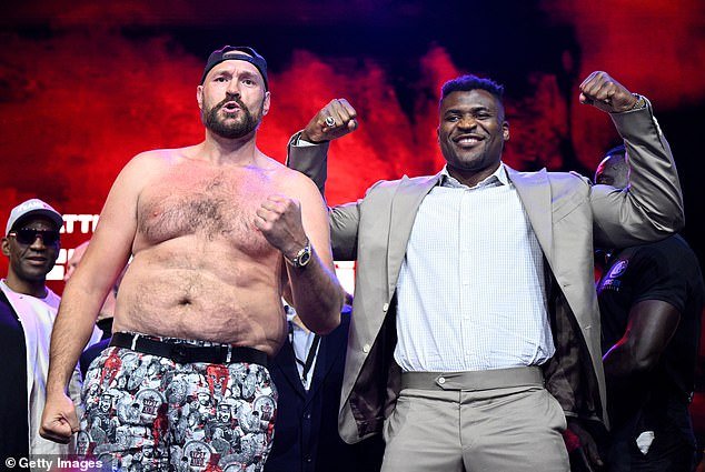 Tyson Fury (L) and Francis Ngannou (R) face each other in the boxing ring on October 28