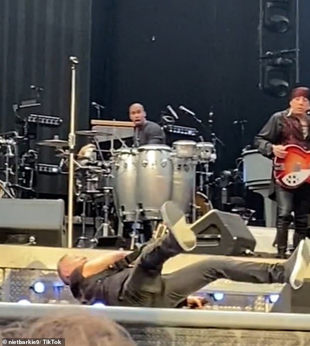 Fans watched as Springsteen rolled onto his back and lay on the ground with his guitar still in hand before his concerned colleagues promptly ran over to help him