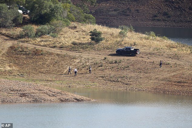 A police search team walks along the bank of the Arade Dam near Silves, Portugal in May 2023