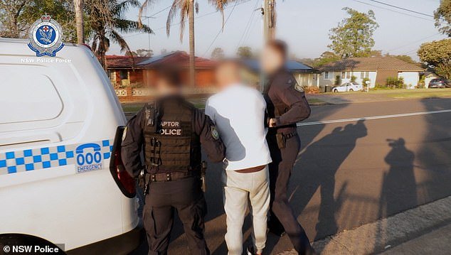 Police arrested two other men from the bikie gang in Hebersham in a series of early morning raids on Tuesday.  A man (pictured) is seen being led away by officers after being charged with separate offences
