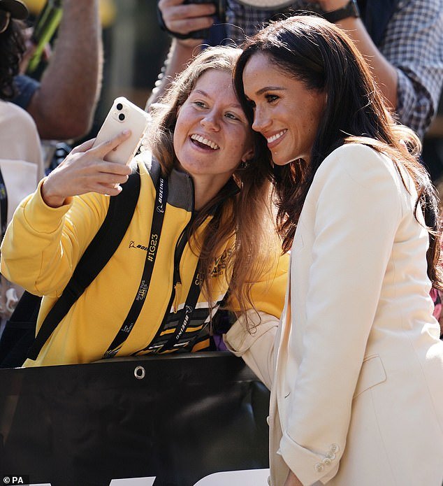 Meghan beamed as she chatted with the delighted crowd waiting for a glimpse of the Duke and Duchess of Sussex