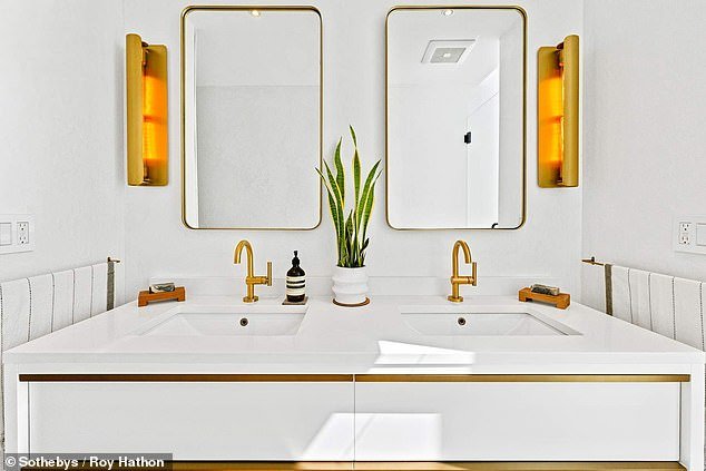 Double sinks in the houseboat bathroom, complete with gold-rimmed mirrors and taps