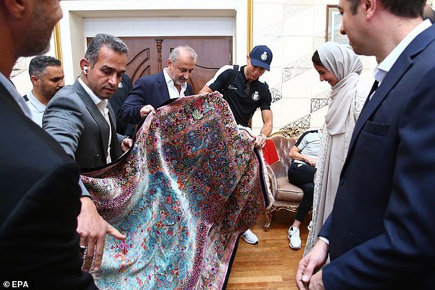 Ronaldo looks at his welcome gift after landing in Tehran on Monday