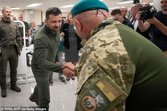 In a large hospital room, the Ukrainian president watched as several soldiers in khaki uniforms practiced walking and lifting weights with newly acquired prosthetic legs and arms.