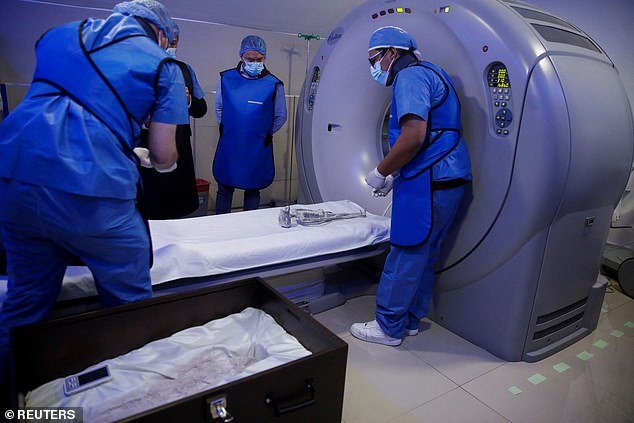 Radiologist technician Guillermo Ramirez prepares to perform a CT scan on a small body of a specimen, which UFO enthusiast Jaime Maussan says is unrelated to any known terrestrial species