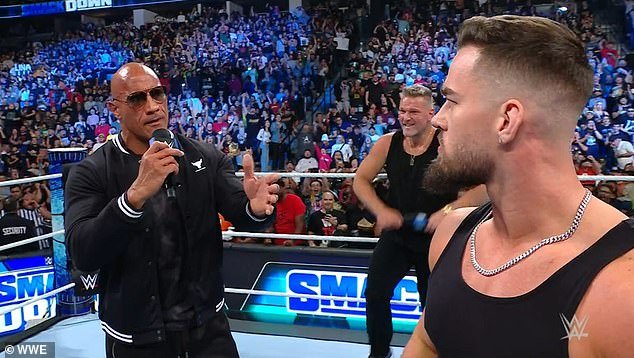 The Hollywood star, real name Dwayne Johnson, appeared in WWE for the first time in three years to confront Austin Theory (right) in the ring