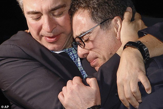 A family member hugs the freed American Siamak Namazi on the asphalt