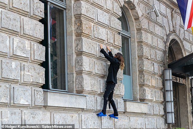Briskly onward: Leto, 51, risked a steep fall to the concrete entranceway and managed to climb above the first-floor windows of the 19th-century hotel