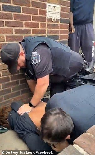 A police officer pulled the man's hoodie over his eyes during the arrest.