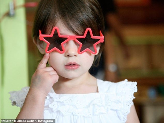 So cute: A second snap featured baby Charlotte wearing coral star-shaped sunglasses and a white eyelet top