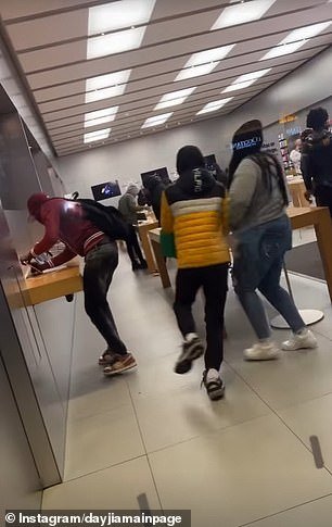 This photo shows one person taking an iPhone from the display