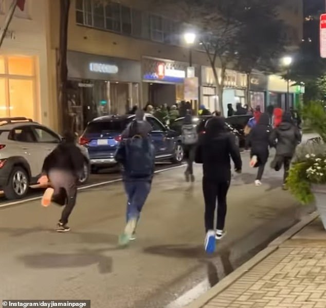 This photo shows groups of people running toward the Lululemon store during the first night of looting