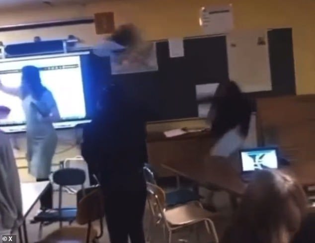 The chair flies off the side of the classroom as the shocked students watch
