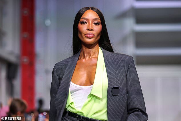 Turning heads: Naomi confidently walked the catwalk as fashion show guests looked on