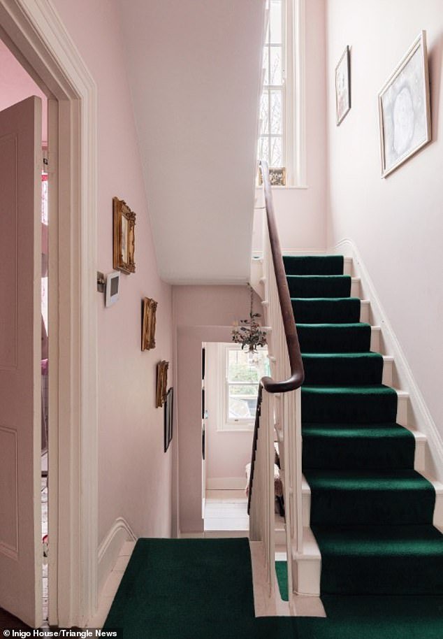 Colors: The walls of the corridor are painted light pink, while the stairs are green