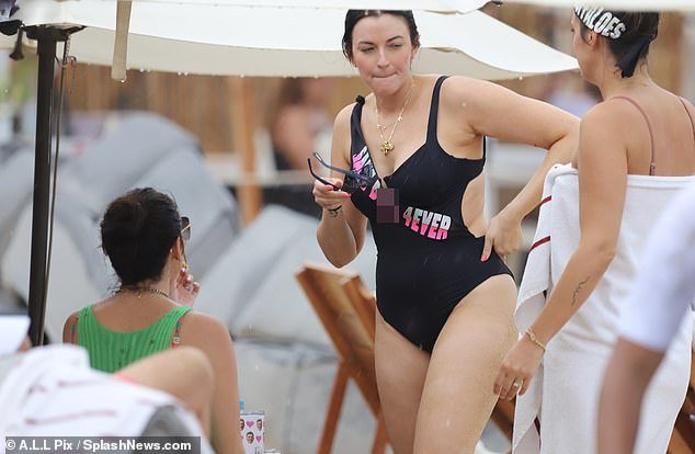 Curvy cutie: Tia's sexy black swimsuit featured a suggestive banner emblazoned across the chest area