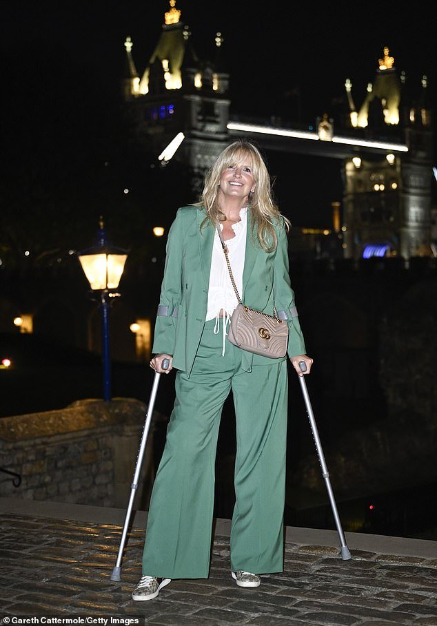 Stunning: Penny exuded elegance in her modern green suit and teamed her ensemble with a white blouse underneath her jacket