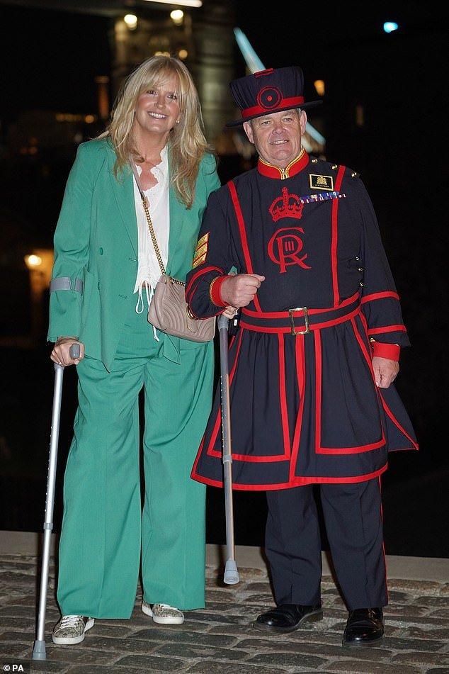 Cute: Penny got a helping hand from the Yeoman Keeper when she arrived at the book launch