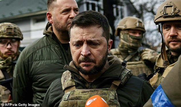President Volodymyr Zelensky (C) speaks to media in the town of Bucha, northwest of the Ukrainian capital Kyiv.  - On March 31, 202, Russian forces withdrew from the commuter town northwest of the capital