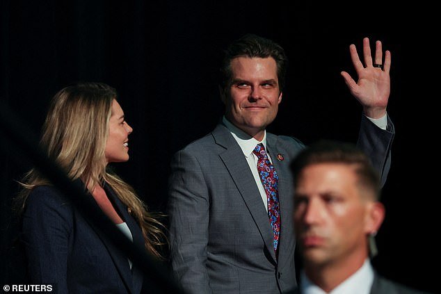 Rep.  Matt Gaetz (right) waves as he is paraded on stage at former President Donald Trump's 'Club 47' event in West Palm Beach, Florida on Wednesday night.  Gaetz was not expected to make the event because of the drama he created on Capitol Hill